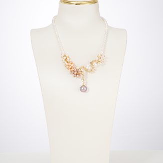 Three-color baroque pearl statement necklace on a white display bust