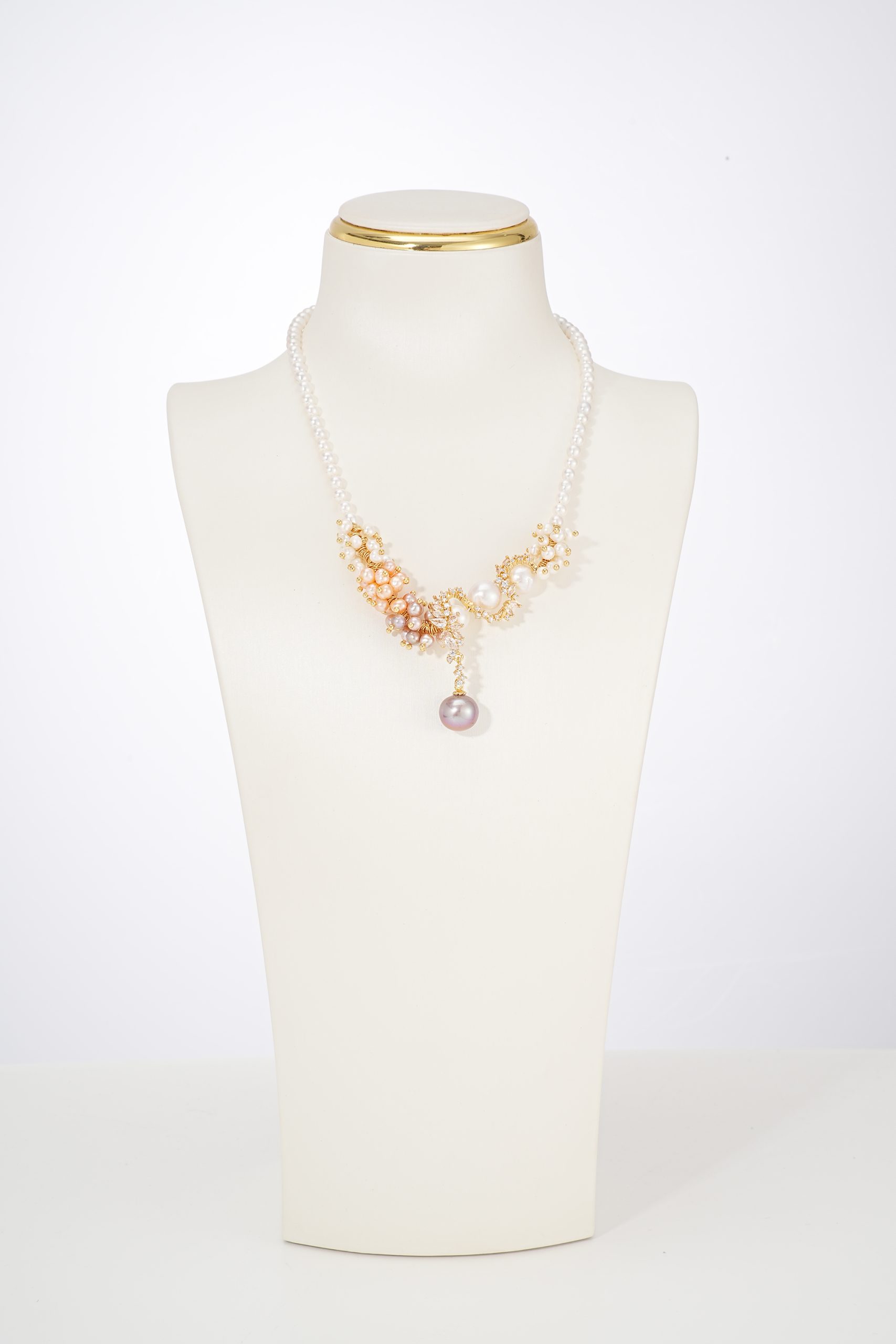 Three-color baroque pearl statement necklace on a white display bust