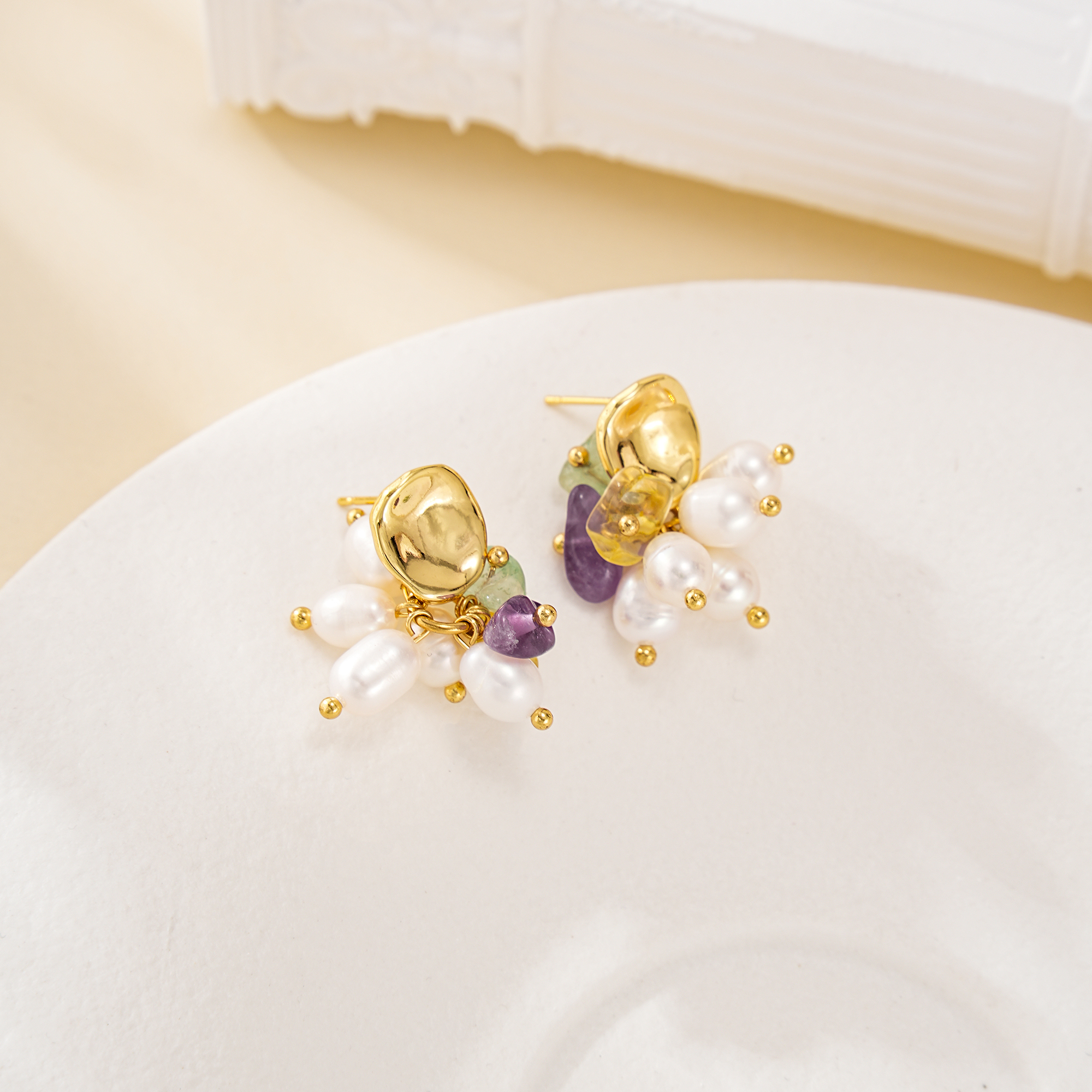 Pearl and multicolour crystal chip cluster earrings laid flat, showing gold-toned studs