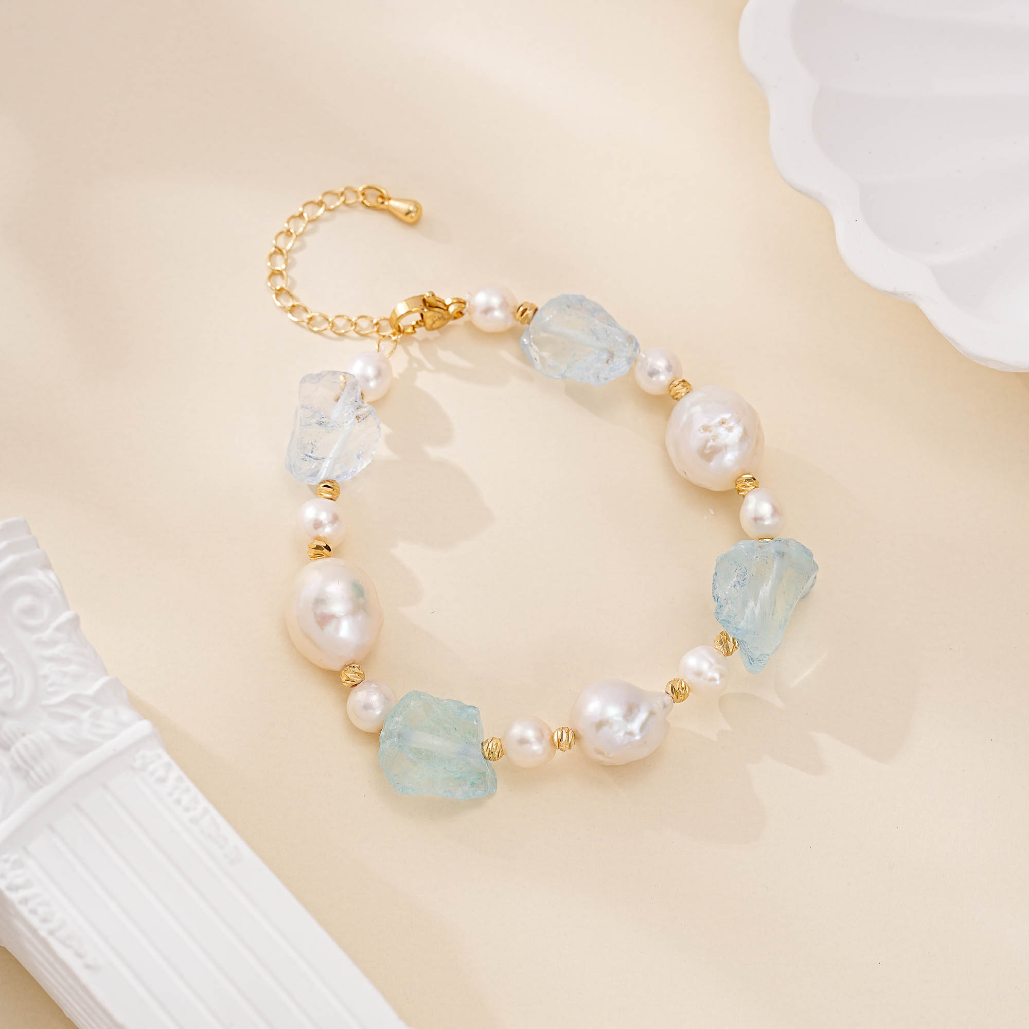Aquamarine and baroque pearl bracelet laid flat, showing its extension chain