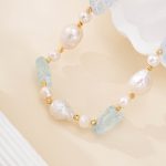 Close-up of aquamarine, baroque pearls and gold-toned spacer beads in a bracelet