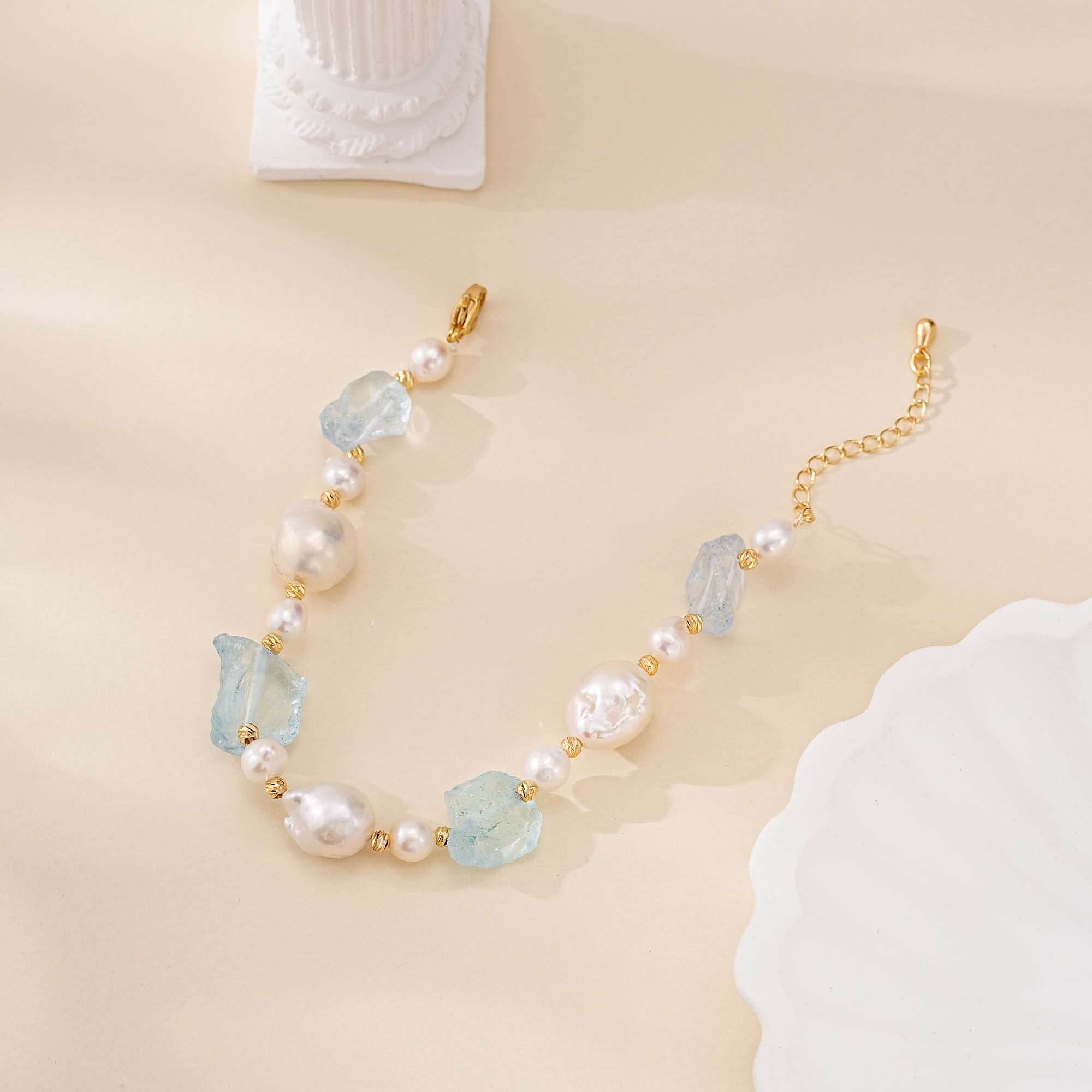 Aquamarine and baroque pearl bracelet arranged in a curve with gold-toned clasp