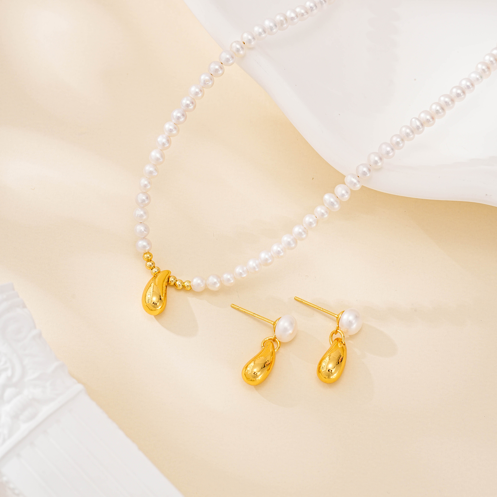 Gold-tone teardrop pearl necklace and matching earrings