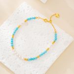 Blue turquoise and white pearl beaded bracelet on a textured white surface