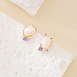 Close view of baroque pearl and purple amethyst stud earrings with irregular metal frames