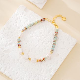 Pastel stone and white pearl beaded bracelet laid flat with gold-tone extender