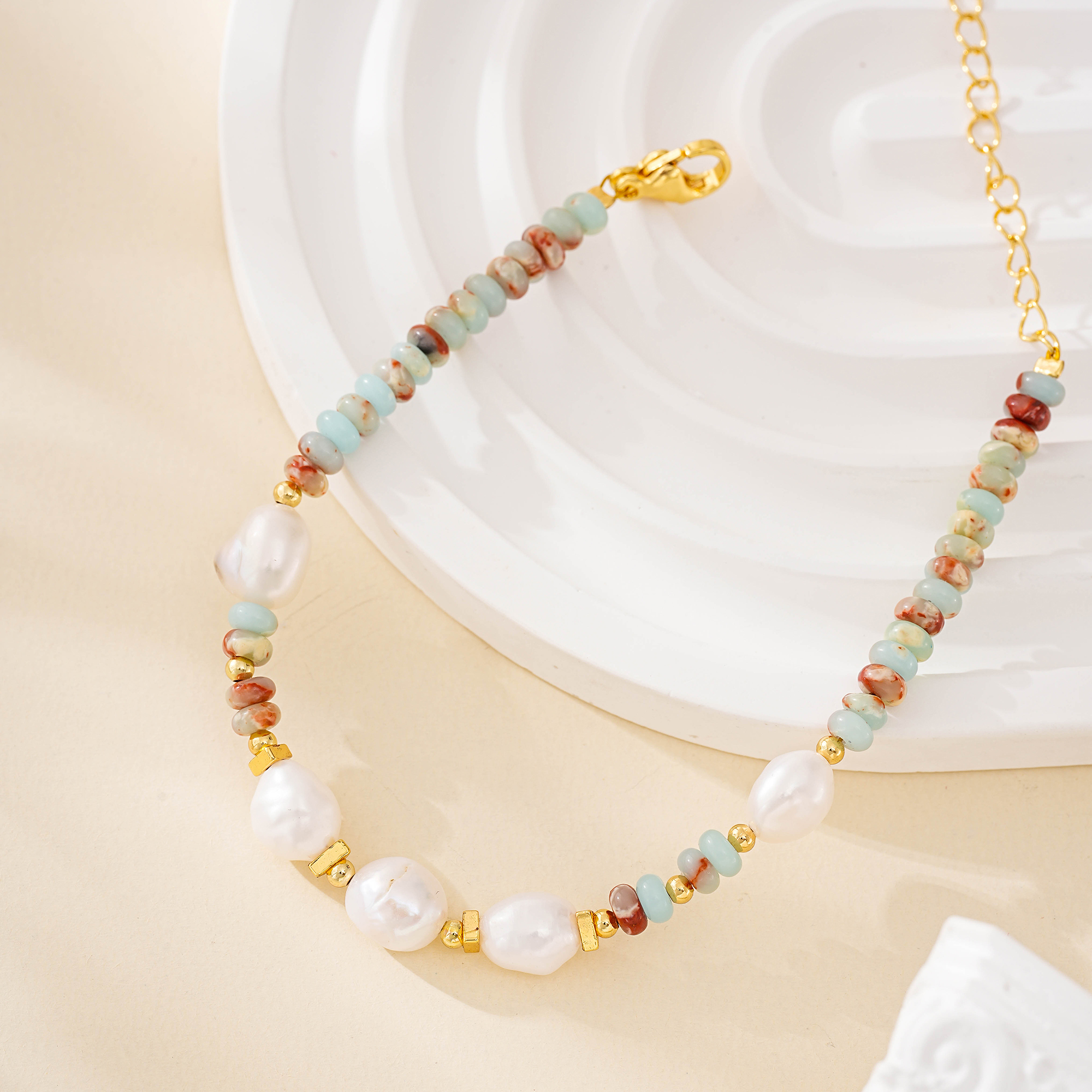 Close view of pastel stone beads and irregular pearls on an adjustable bracelet