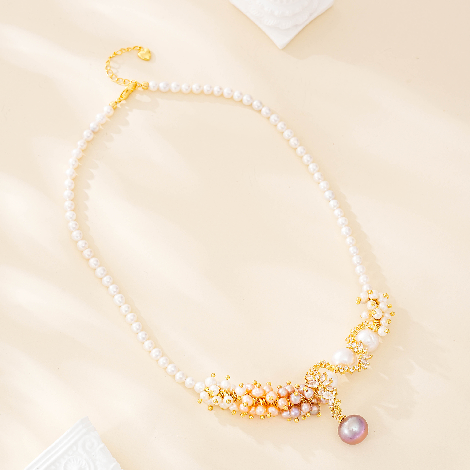 Three-color baroque pearl statement necklace with clustered blush pearls and lilac pearl drop