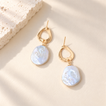 Baroque pearl drop earrings with irregular open gold-tone stud tops laid flat
