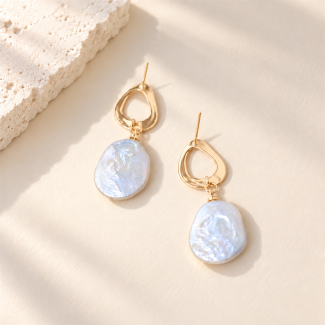 Baroque pearl drop earrings with irregular open gold-tone stud tops laid flat