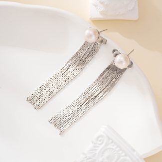 Close view of pearl stud earrings with silver-tone chain tassels