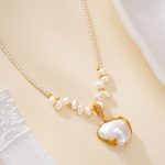 Close-up of pearl accents and sculptural pendant necklace