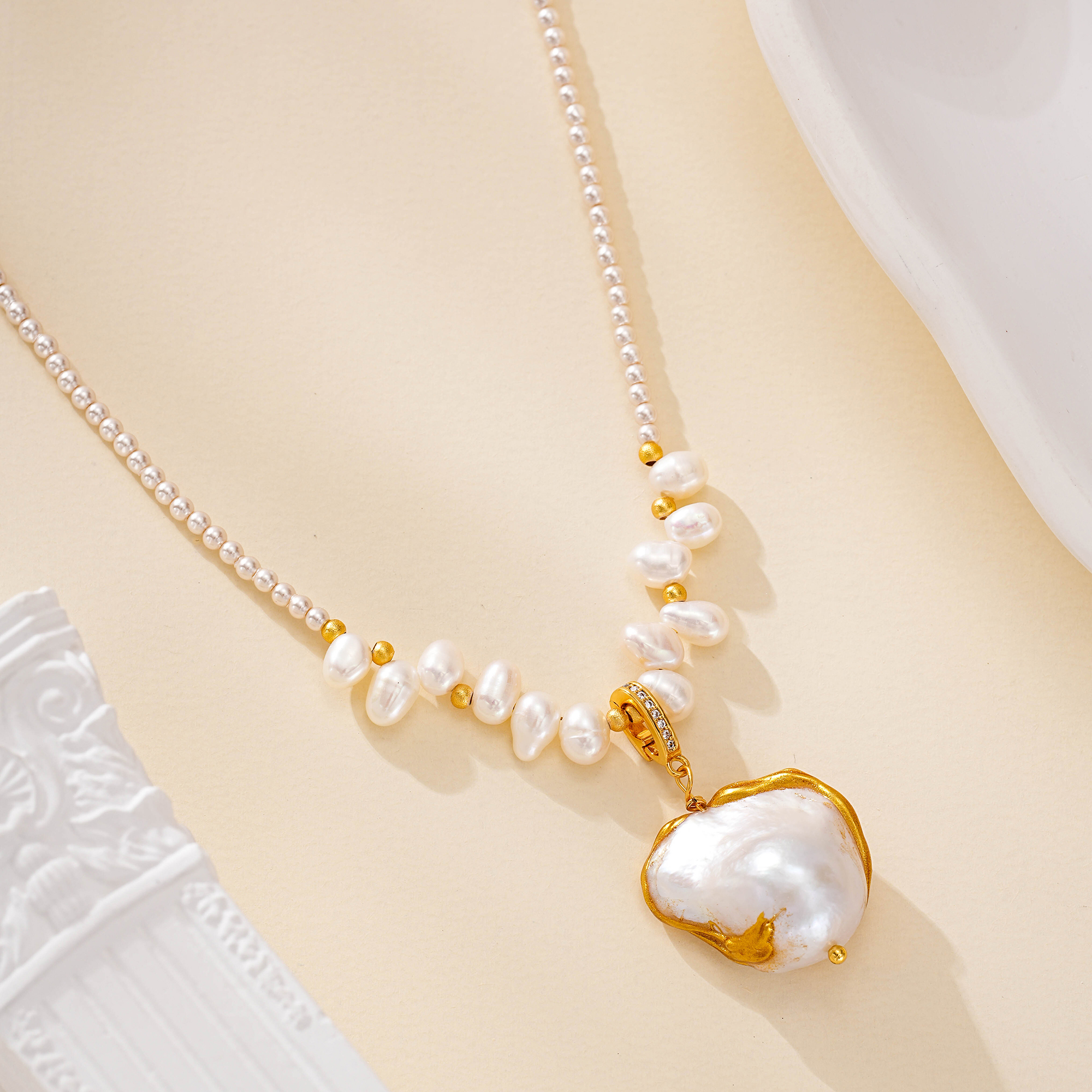 Close-up of pearl accents and sculptural pendant necklace