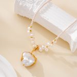 White and gold-tone pendant on a pearl-accented necklace