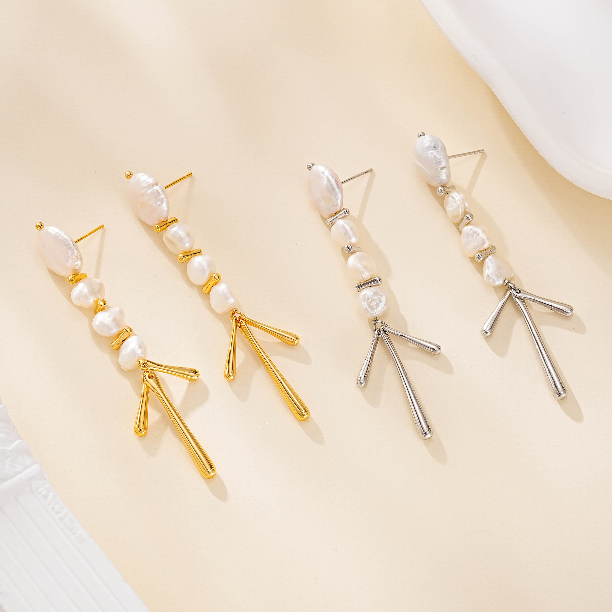 Gold-tone and silver-tone baroque pearl chandelier earrings side by side