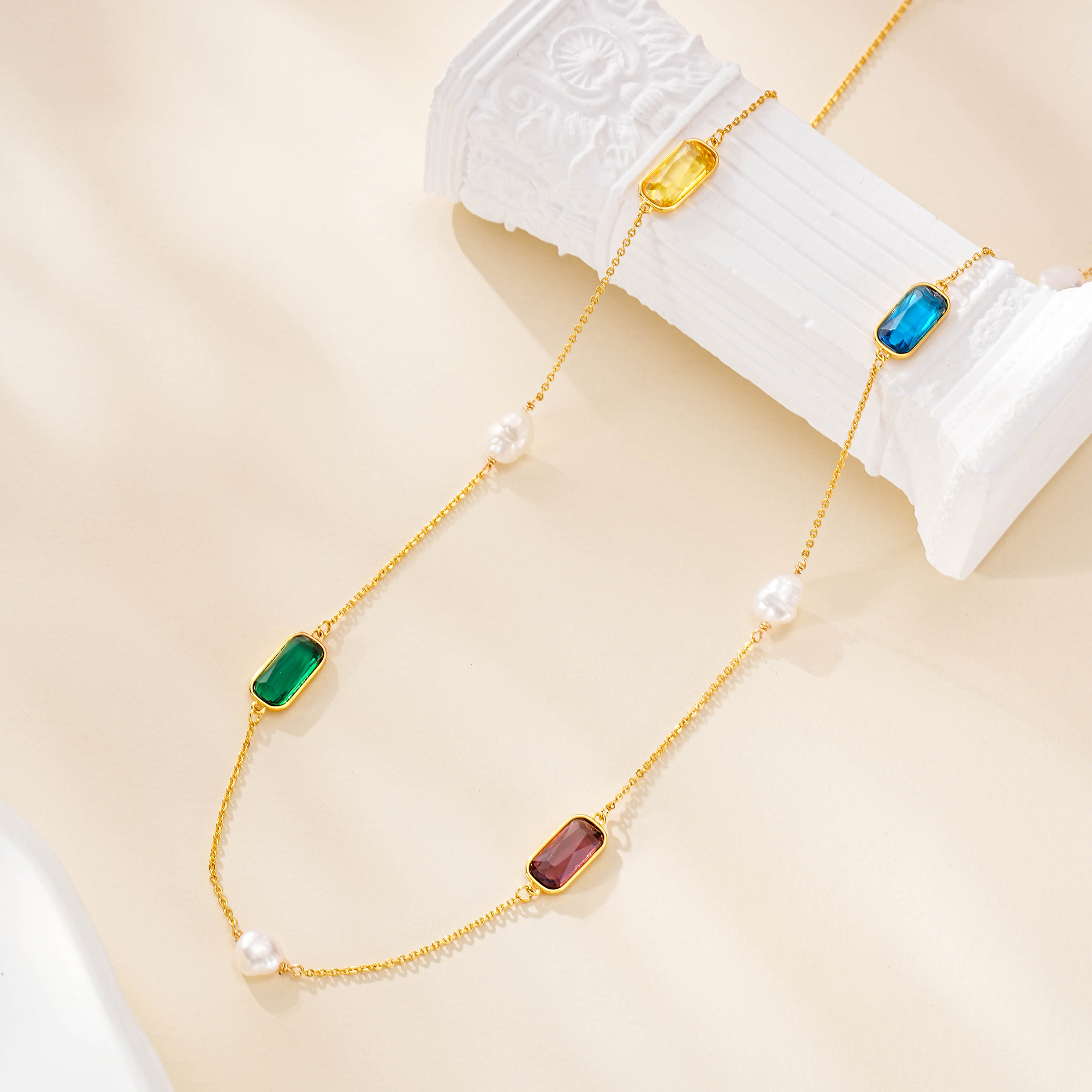 Multicolor gemstone necklace draped over a white sculptural display