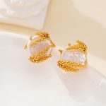 Close-up of gold-tone wheat detail curling around baroque pearl studs