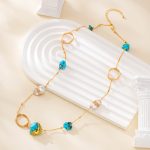 Turquoise and pearl necklace laid across a white curved display