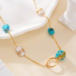 Turquoise pendant beside wire-wrapped pearls and a gold-tone ring