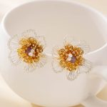 Floral stud earrings with silver-tone wire petals on a white display