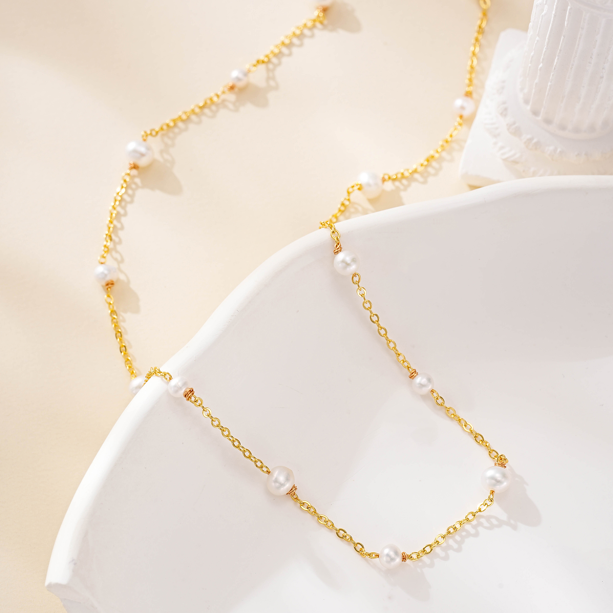 Two pearl layering necklaces draped together