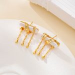 Side view of sculptural pearl earrings with dangling chains