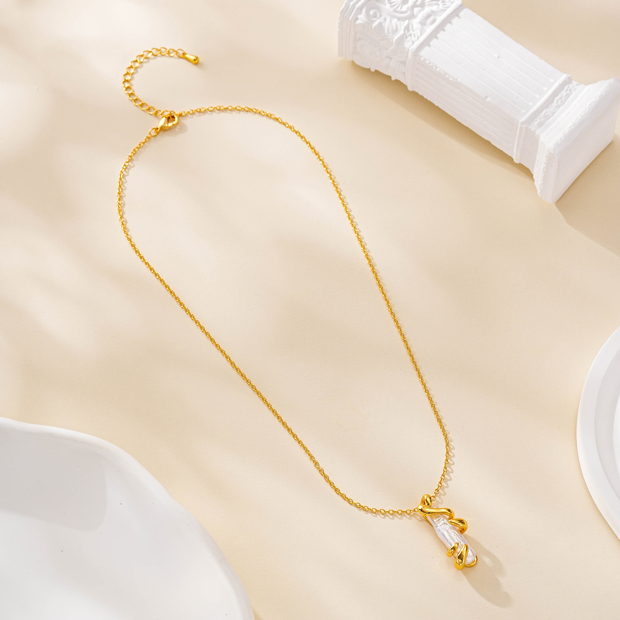 Gold-tone chain necklace with spiral-wrapped pearl pendant