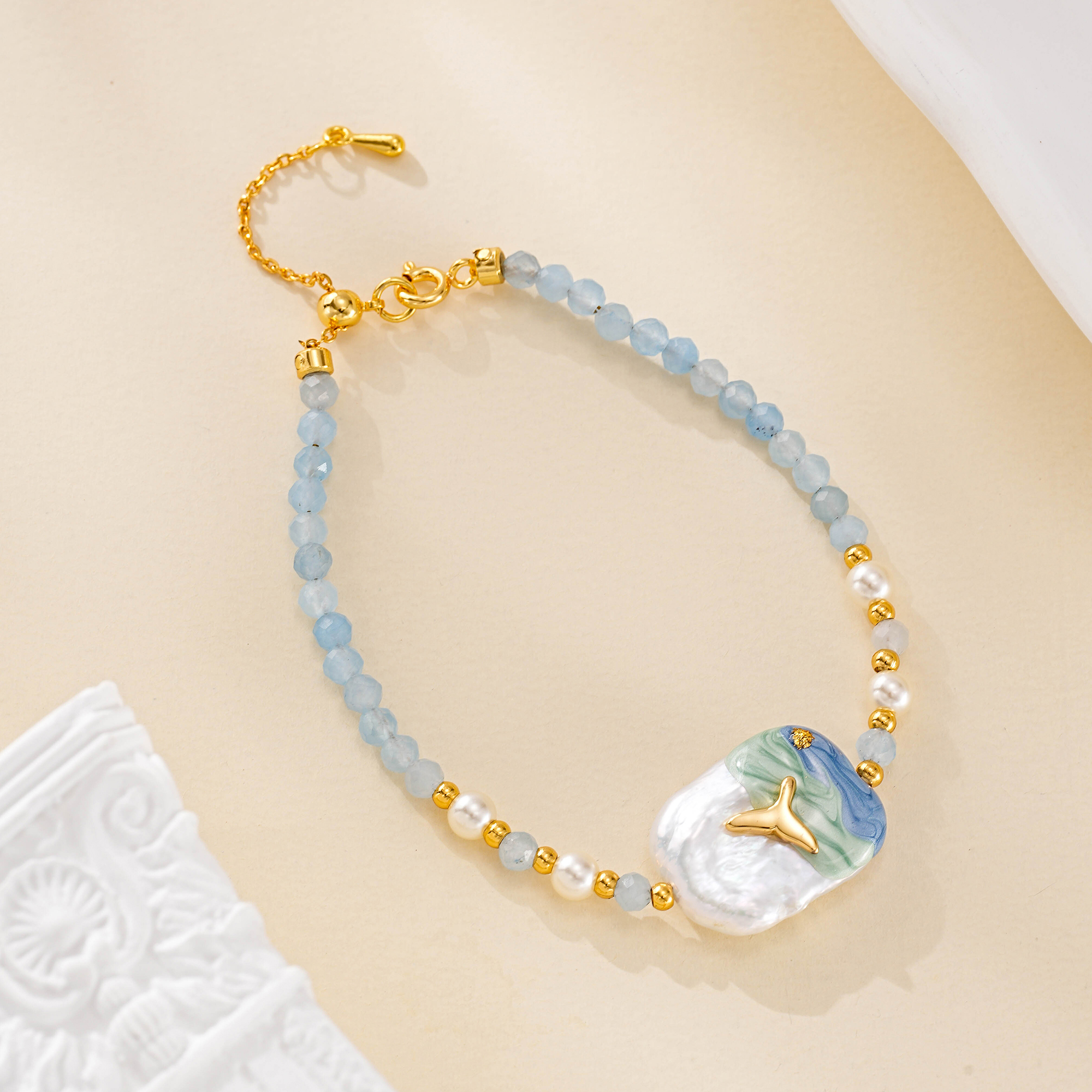 Blue beaded bracelet with painted baroque pearl centerpiece