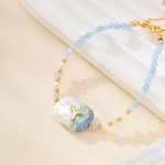 Close-up of ocean-painted pearl and blue bead bracelet