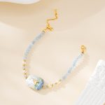 Full view of blue bead bracelet with painted pearl charm