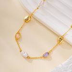 Close-up of pastel oval stones and pearls on gold-tone bracelet