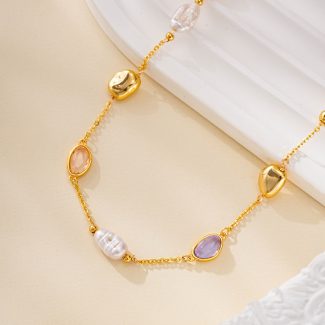 Close-up of pastel oval stones and pearls on gold-tone bracelet