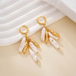 Baroque pearl and bar tassel earrings beside white column