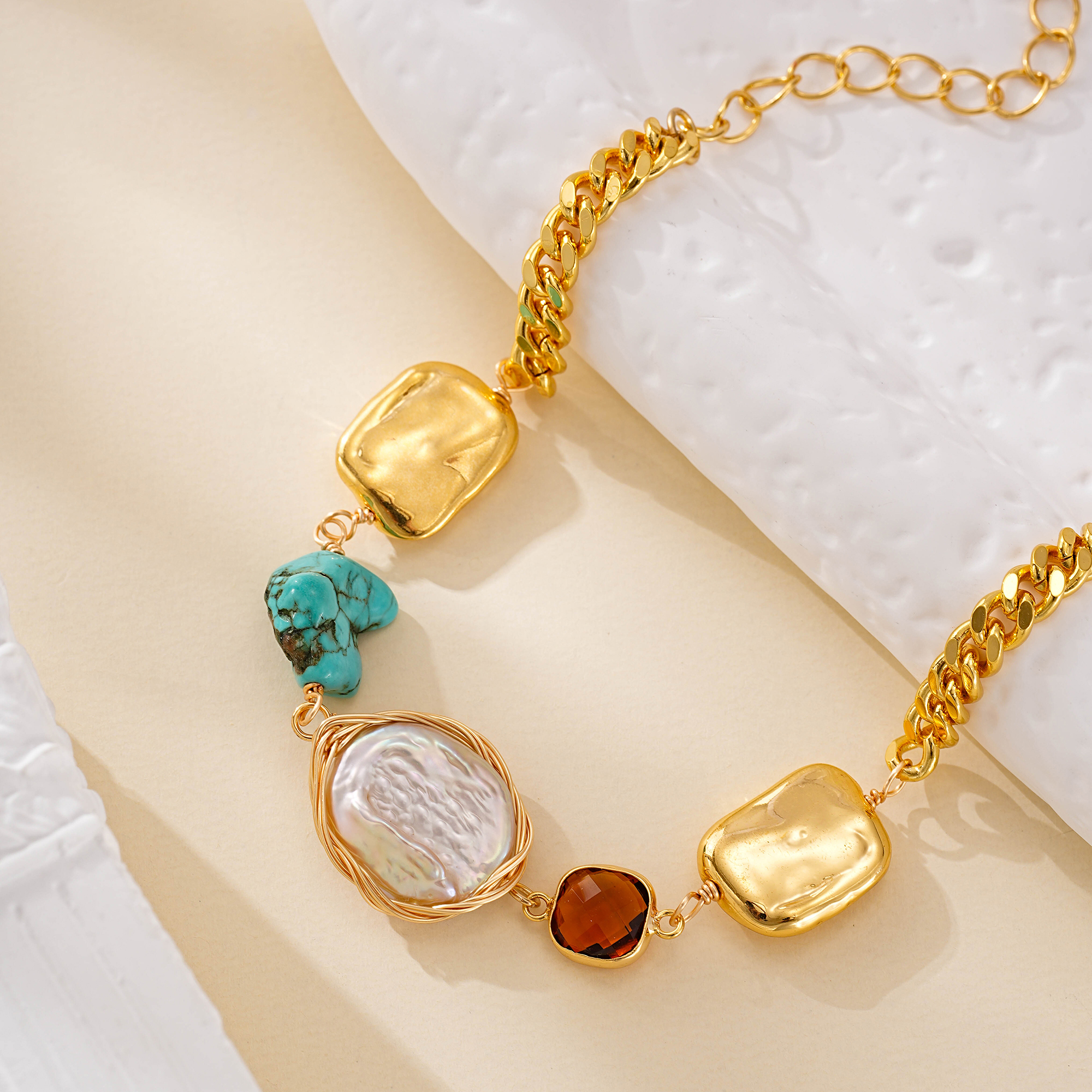 Close-up of turquoise and pearl details on a mixed-link bracelet
