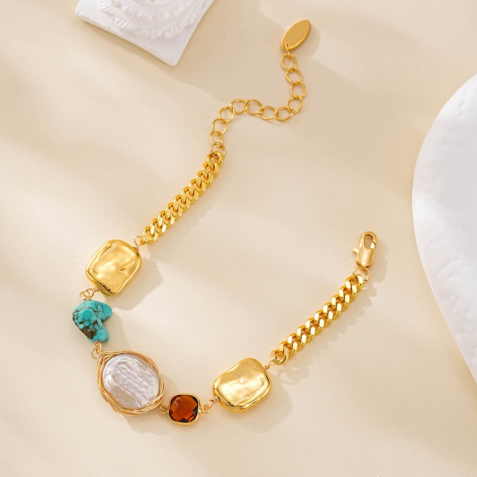 Gold-tone mixed-link bracelet laid open with turquoise and pearl accents