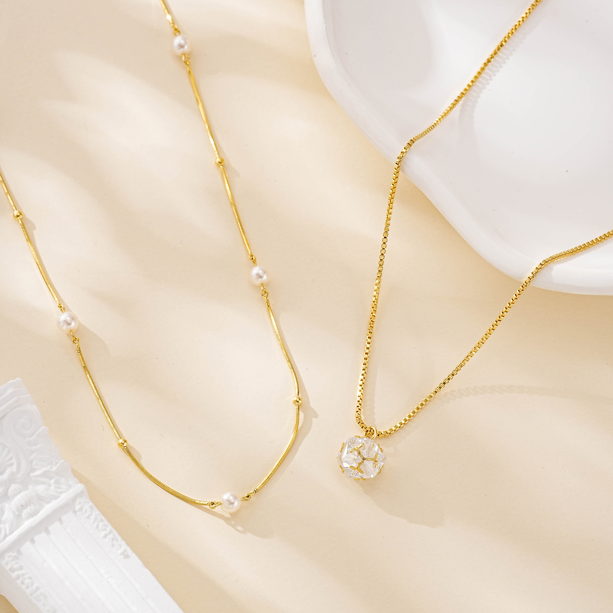 Layered pearl and crystal necklace set shown together on a cream backdrop