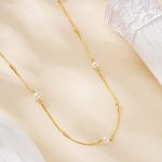 Short gold-tone necklace with freshwater pearls spaced along the chain
