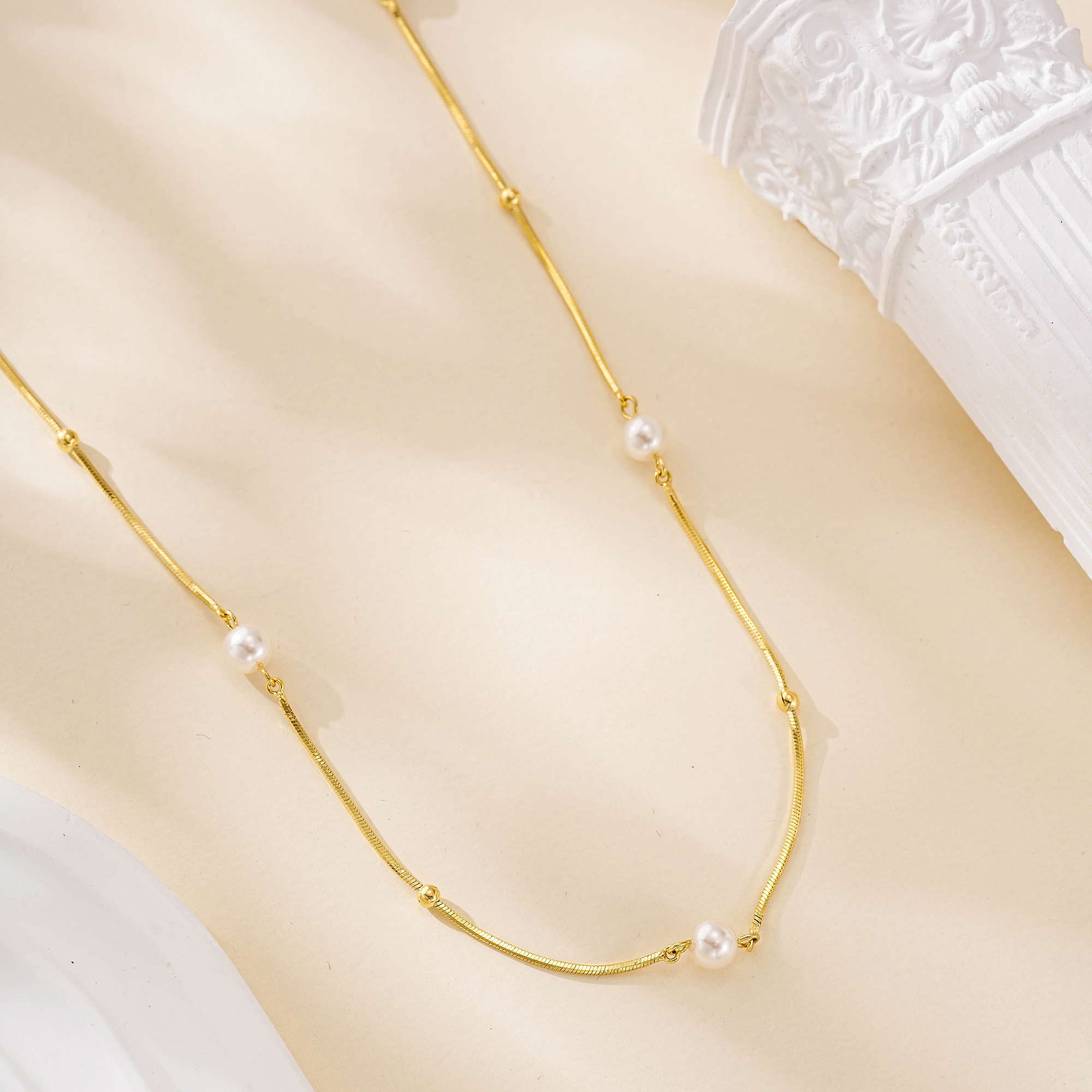 Short gold-tone necklace with freshwater pearls spaced along the chain