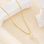 Long crystal pendant necklace draped beside white columns