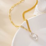 Close view of the baroque pearl hanging between contrasting chains
