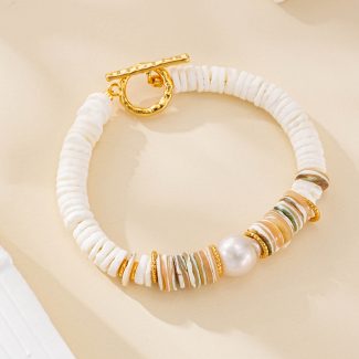 Shell disc bracelet with a round freshwater pearl on a light backdrop