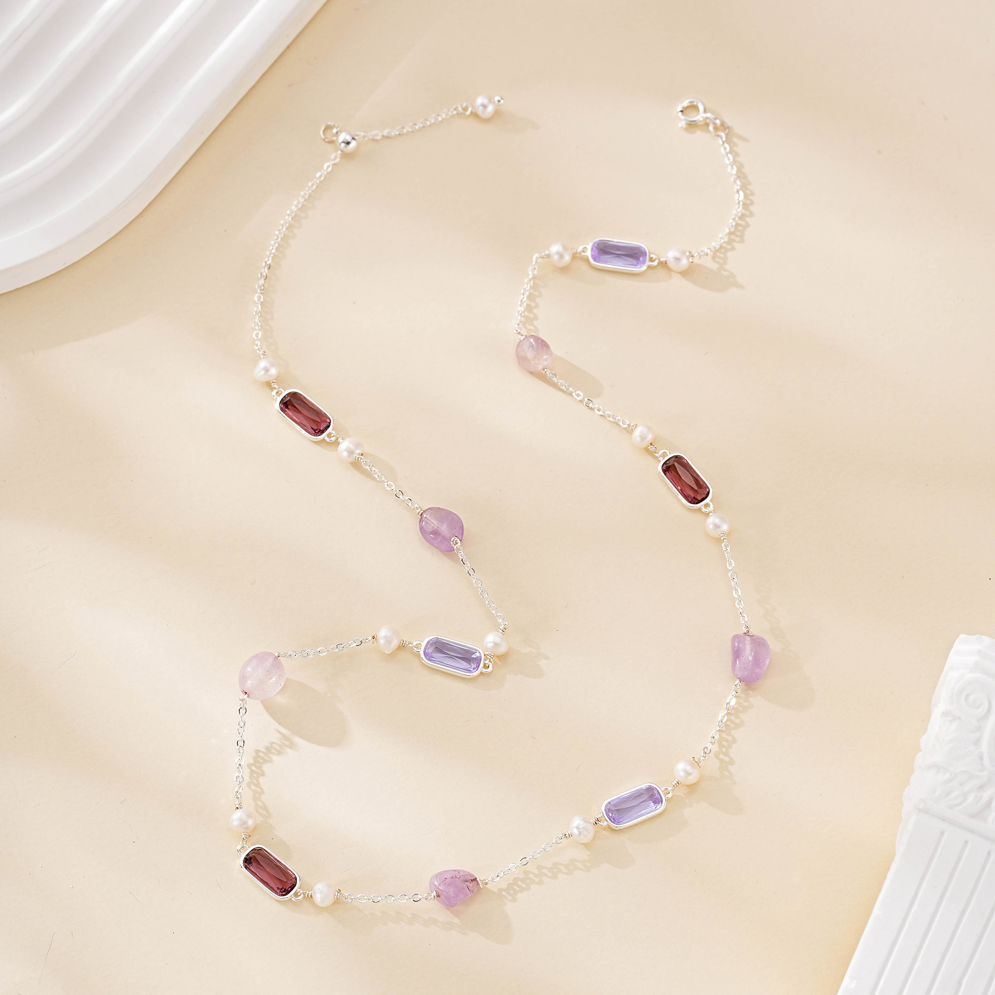 Fine chain showing alternating purple gemstones and freshwater pearls
