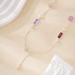 Close-up of purple gemstone and pearl accents on silver-tone necklace