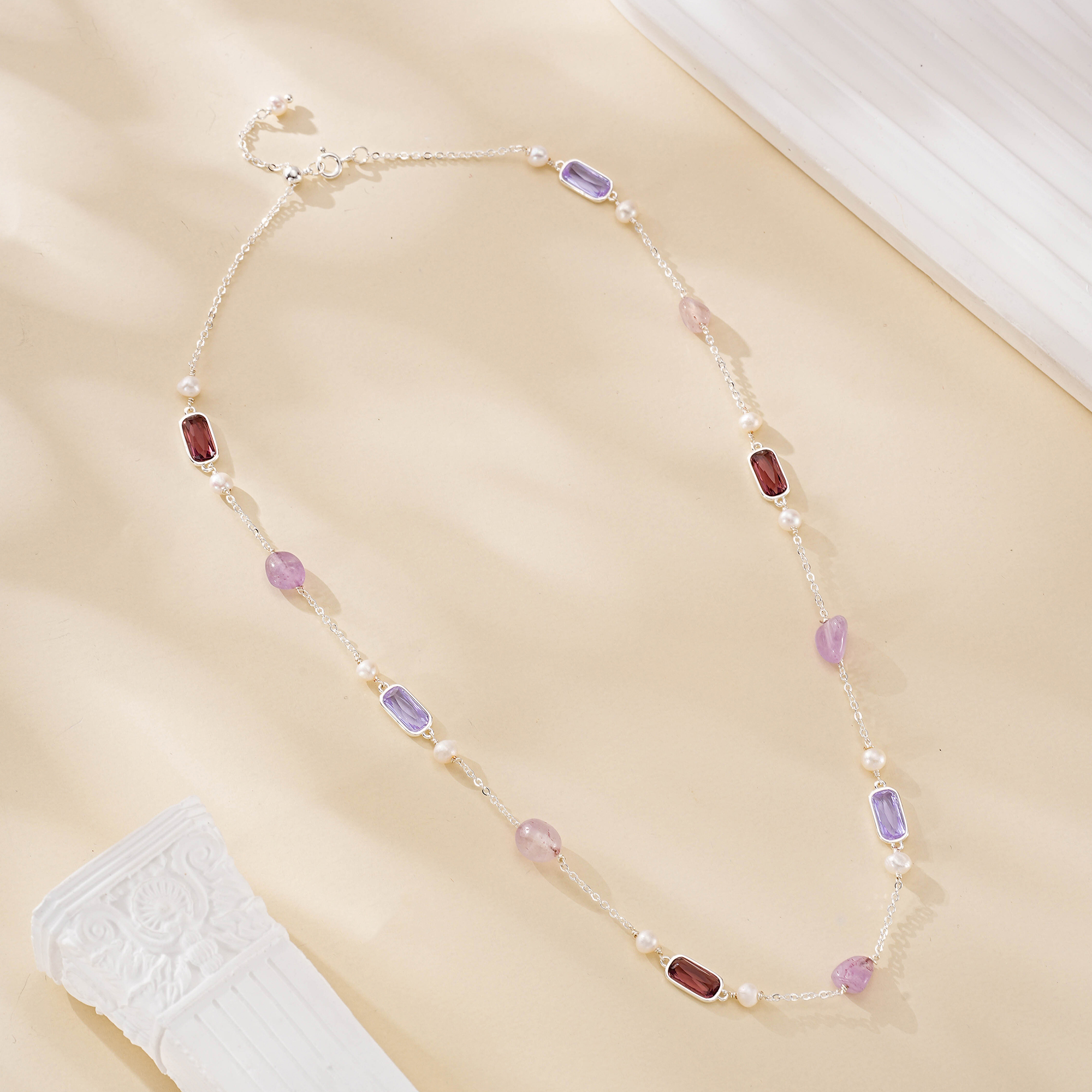 Delicate mixed gemstone and pearl necklace laid out