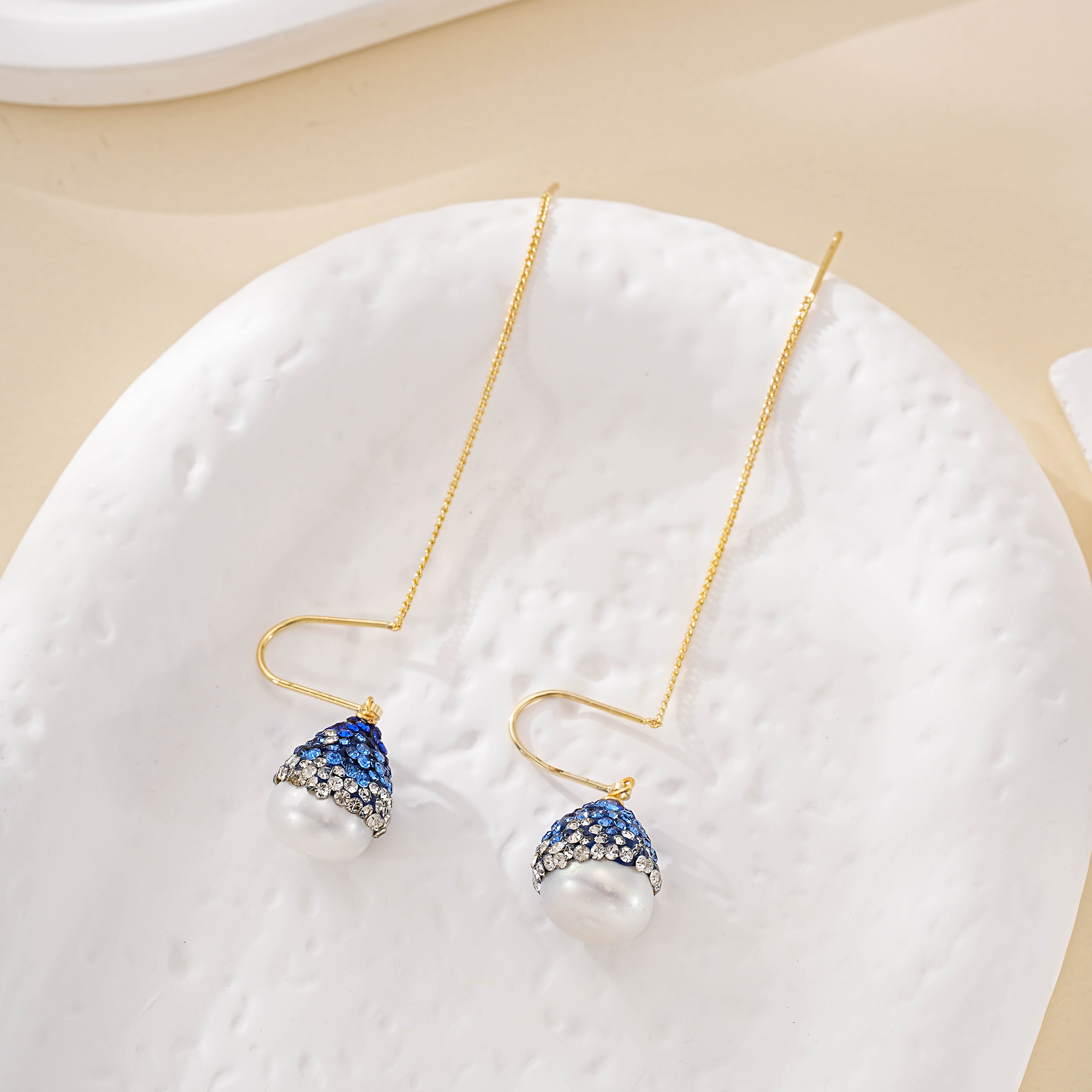 Detail of blue accented baroque pearl threader earrings