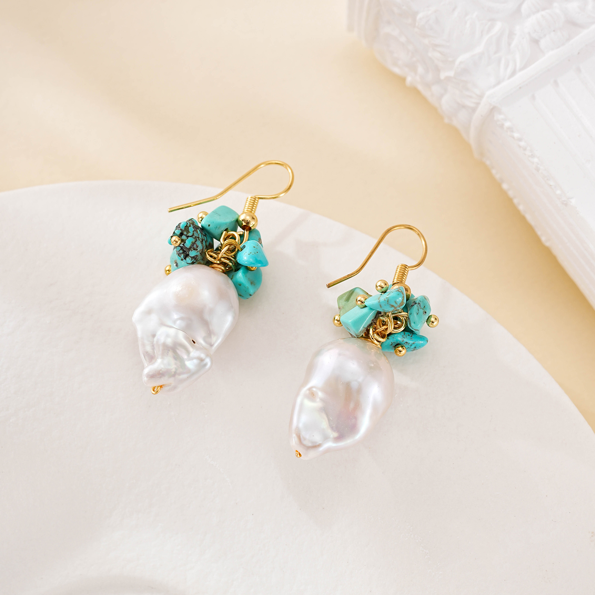 Close view of turquoise stones above irregular pearl drops