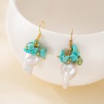 Pair of turquoise and baroque pearl drop earrings on a light backdrop