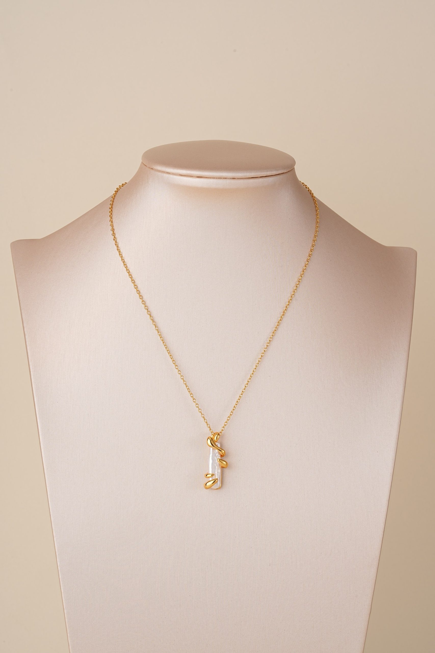 Spiral baroque pearl necklace displayed on a bust