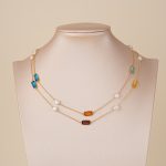 Multicolor gemstone and pearl necklace doubled on a bust