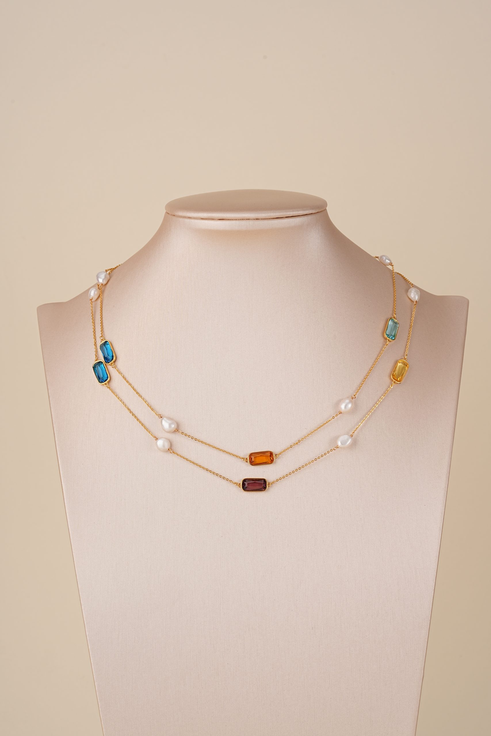 Multicolor gemstone and pearl necklace doubled on a bust